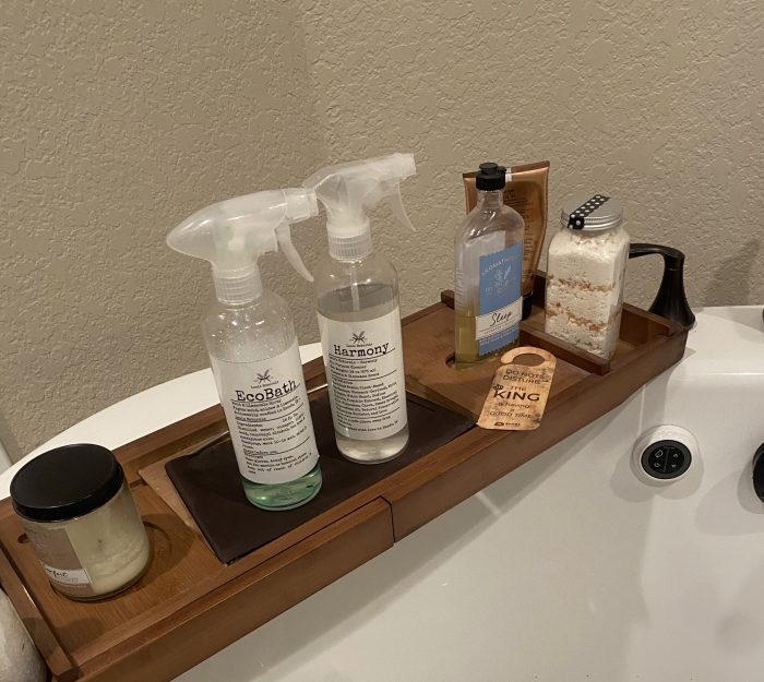 Leal&rsquo;s spray bottles on a wooden tray beside a bathtub